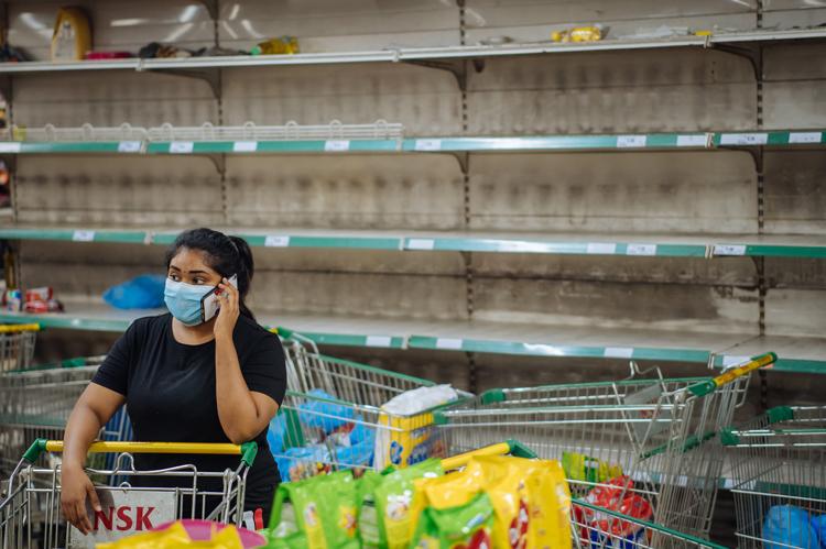3月17日凌晨，在马来西亚吉隆坡一家超市，一名女士站在空货架前。.jpg