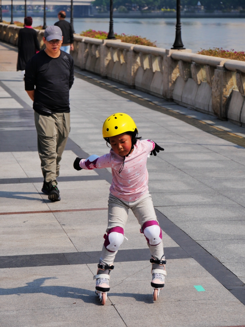 2021年2月20日，广州二沙岛，女儿在学习溜冰鞋父亲在身后看着。.JPG