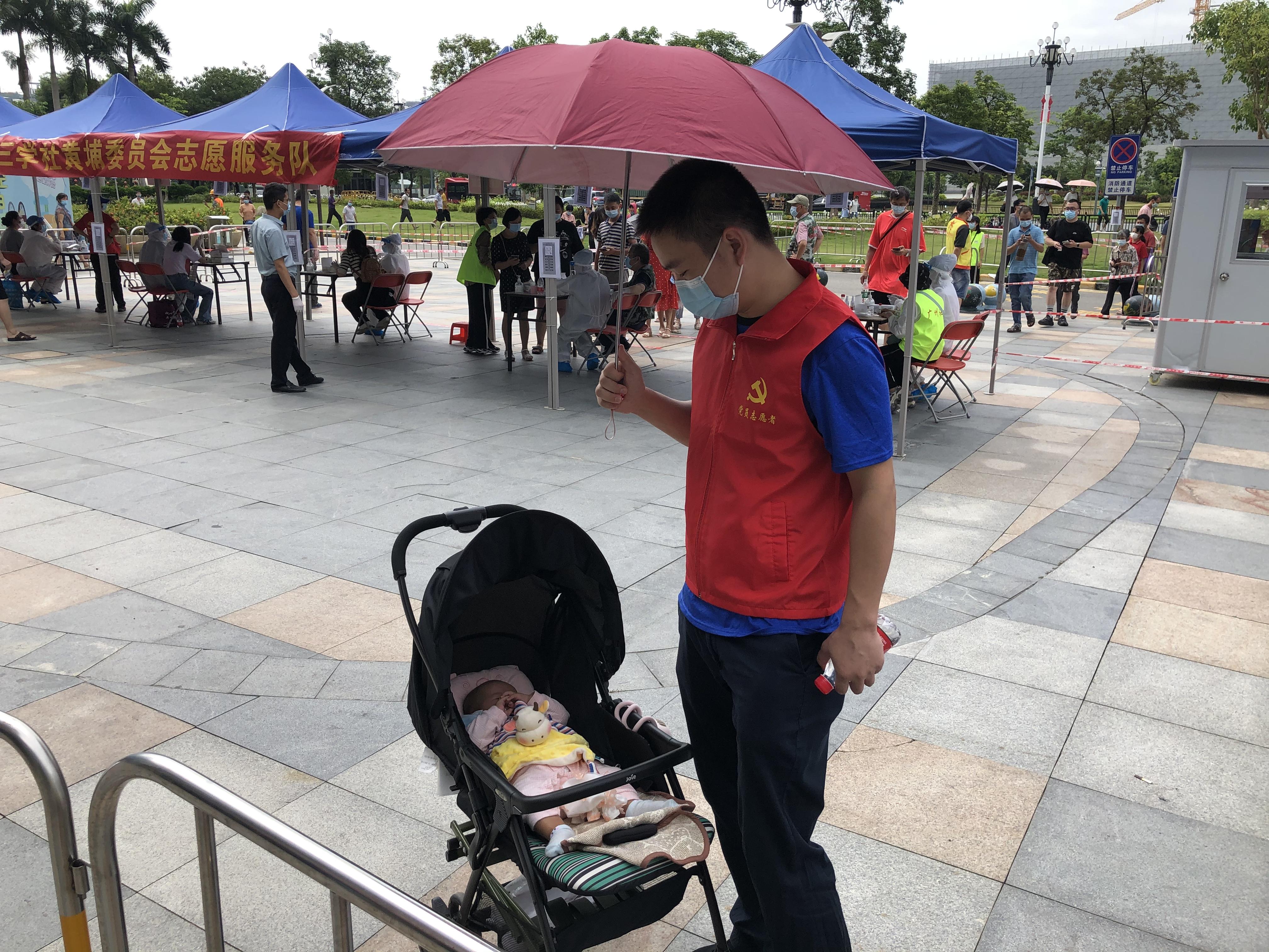 广州红马甲给小婴儿撑伞遮阳宝宝背后竟有3位抗疫家属